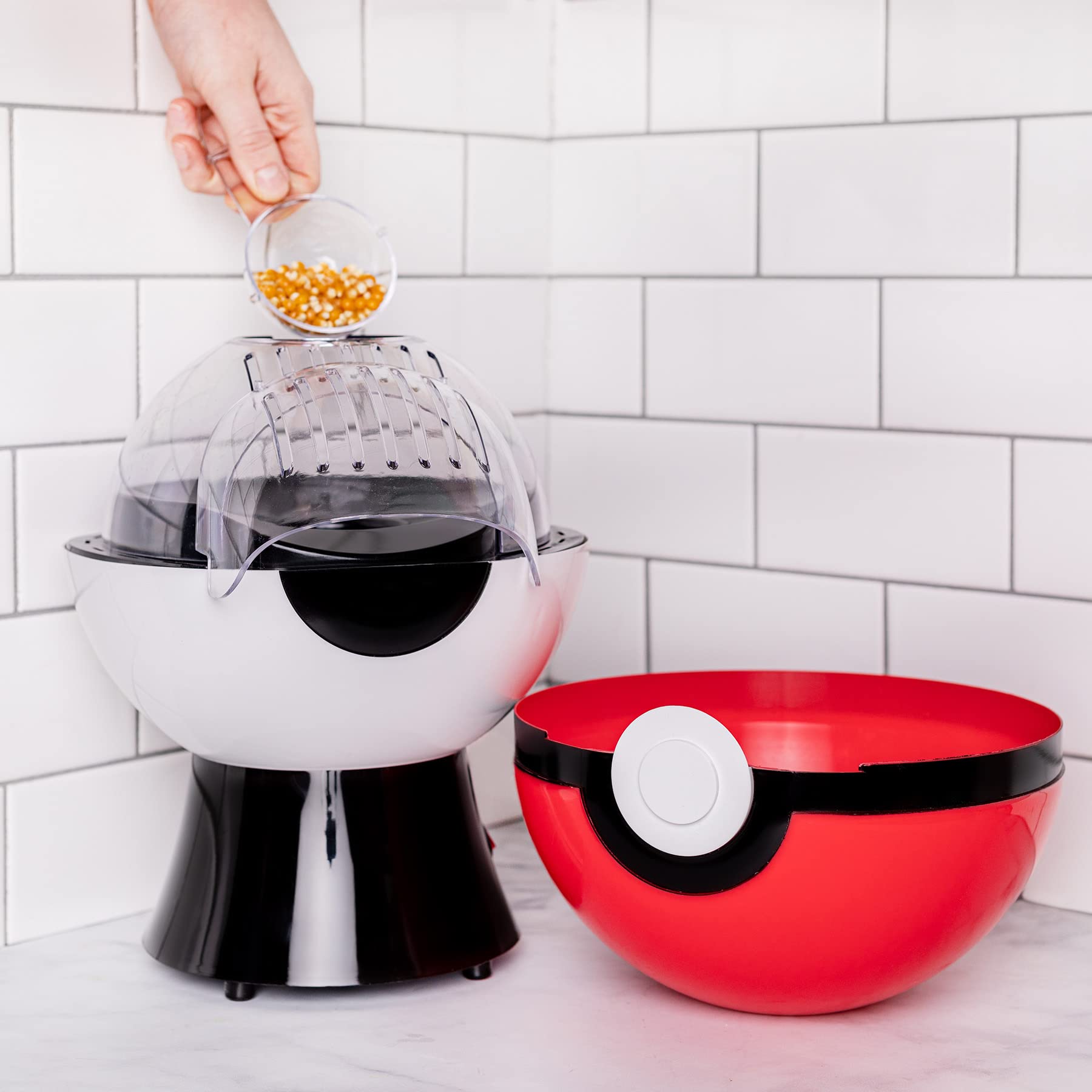 Uncanny Brands Poké Ball Popcorn Maker con tapa doble para servir.