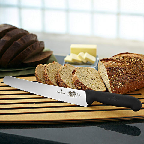Cuchillo Victorinox para pan, corte uniforme en la mesa.