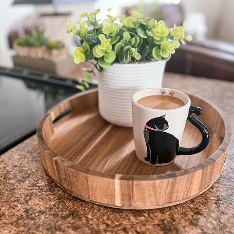 Detalles negros y silueta de gato en la taza blanca.
