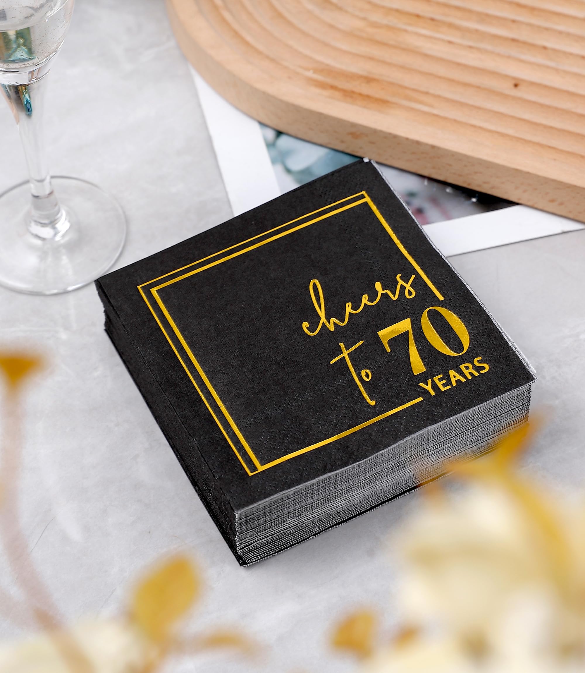 Cheers to Years de Winoo Design, diseño negro y dorado que realza la mesa de cumpleaños.