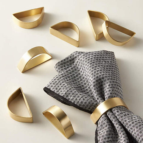 Anillos de servilleta dorados mate Wonlex en semicírculo para una mesa elegante.