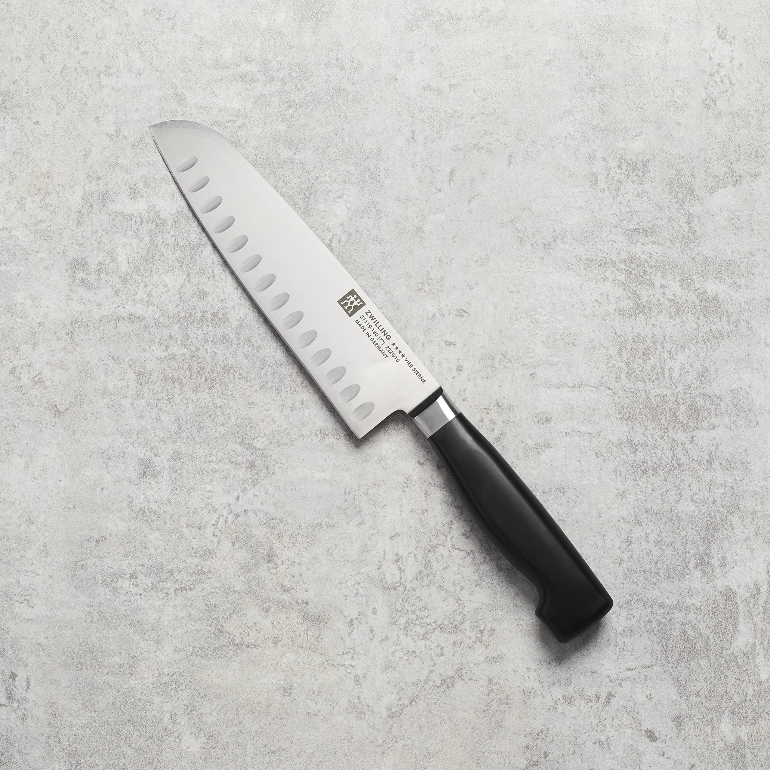 ZWILLING Cuatro Estrellas Santoku hoja con borde hueco para liberar rebanadas.