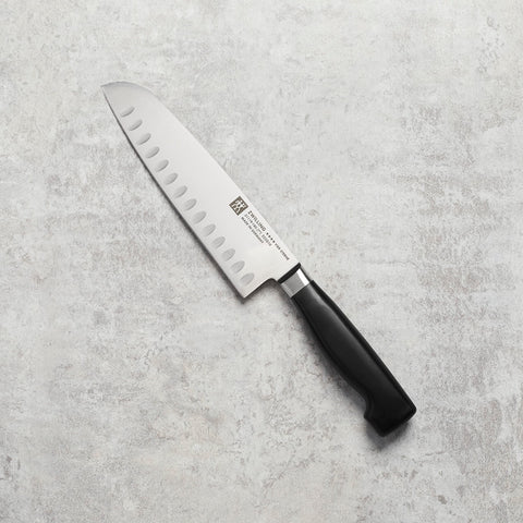 ZWILLING Cuatro Estrellas Santoku hoja con borde hueco para liberar rebanadas.